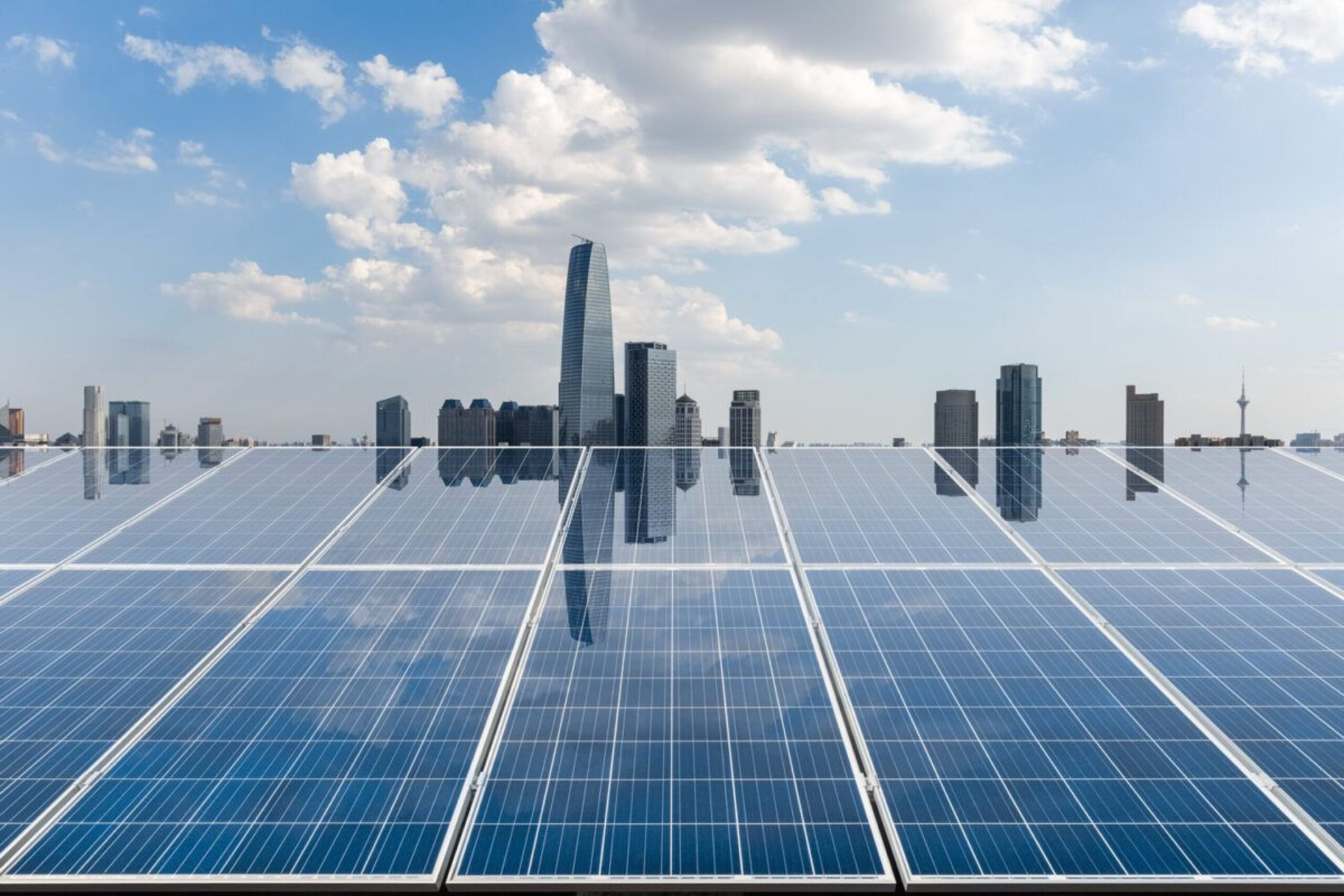 A wide shot of a large commercial rooftop covered in rows of newly installed solar panels under a cloudy sky.