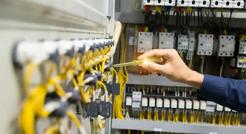 Close-up of an ENV Electric technician performing live voltage testing using a specialized tool, emphasizing safety and precision in Industrial Electrical Services in Oshawa Ontario.