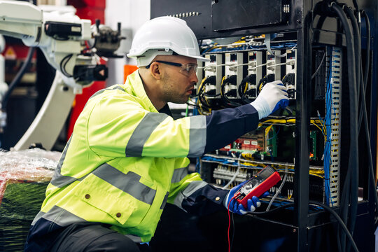 An Env Electric technician performing a voltage test on a complex commercial circuit breaker panel in Durham.