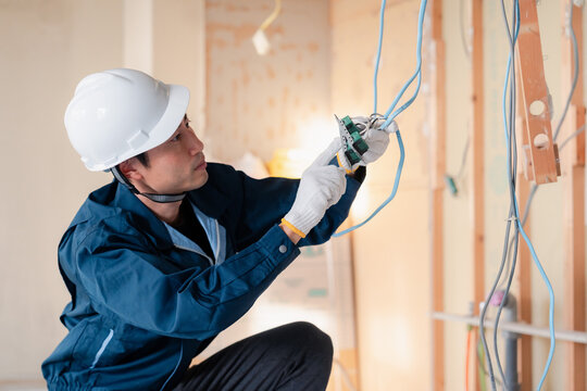 Licensed electrician performing professional electrical contracting services in Durham and Oshawa, repairing a residential circuit breaker panel.
