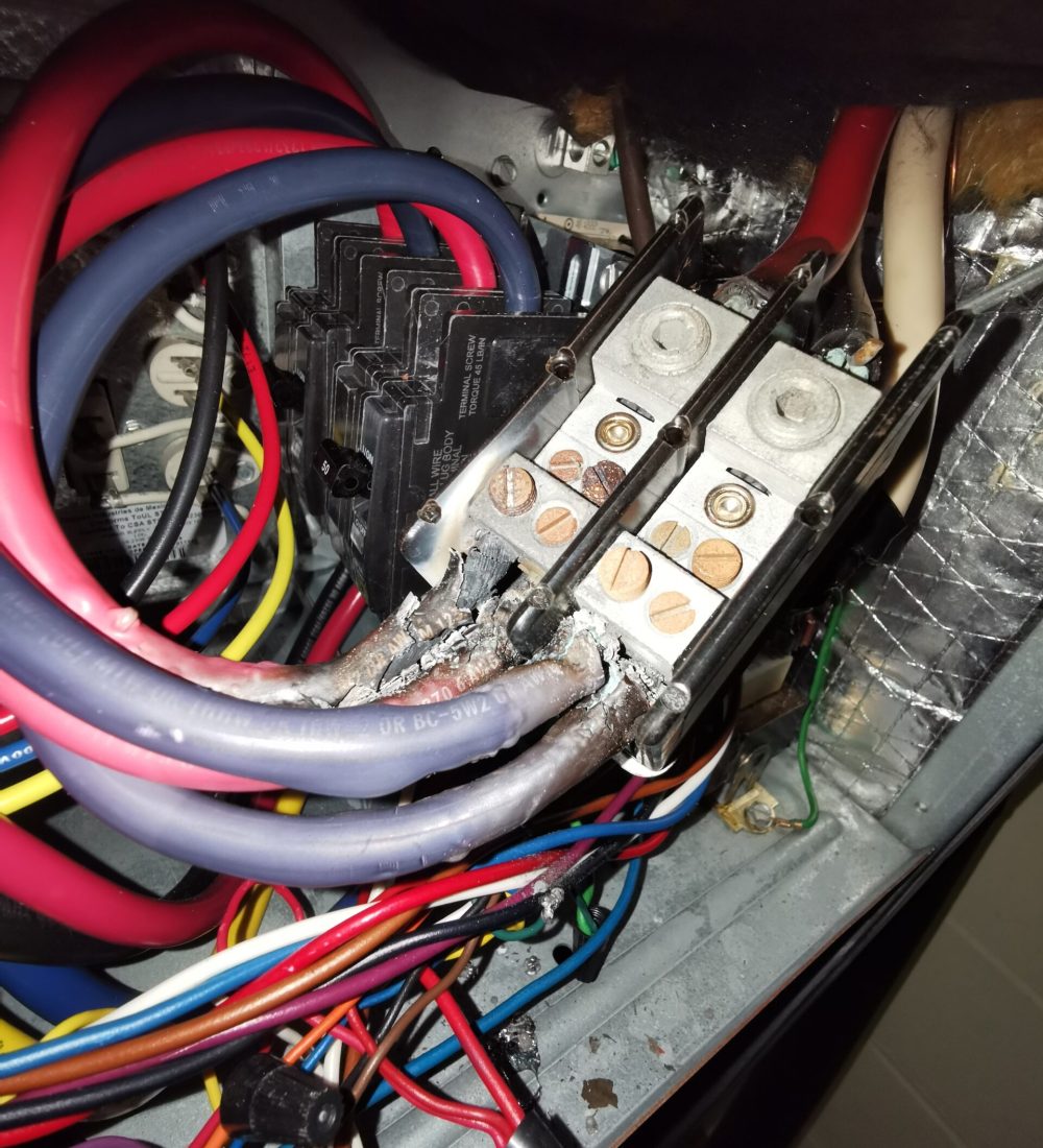 Burnt Electrical Wires and Overheated Panel Electrical panel with burnt and damaged wires showing signs of overheating and potential fire hazard.